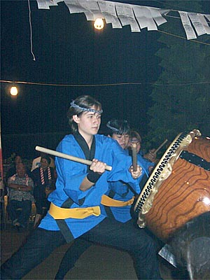 [ A high point of the evening was the performance of the youth taiko drum troupe. It was a smaller group than in years past, but no less rousing. Jen and I were worried that Katie would freak at the thundering wall of sound, but she didn't. In fact, she jumped up, ran around to stand behind us, and proceeded to thump Jen and I on the head. ]